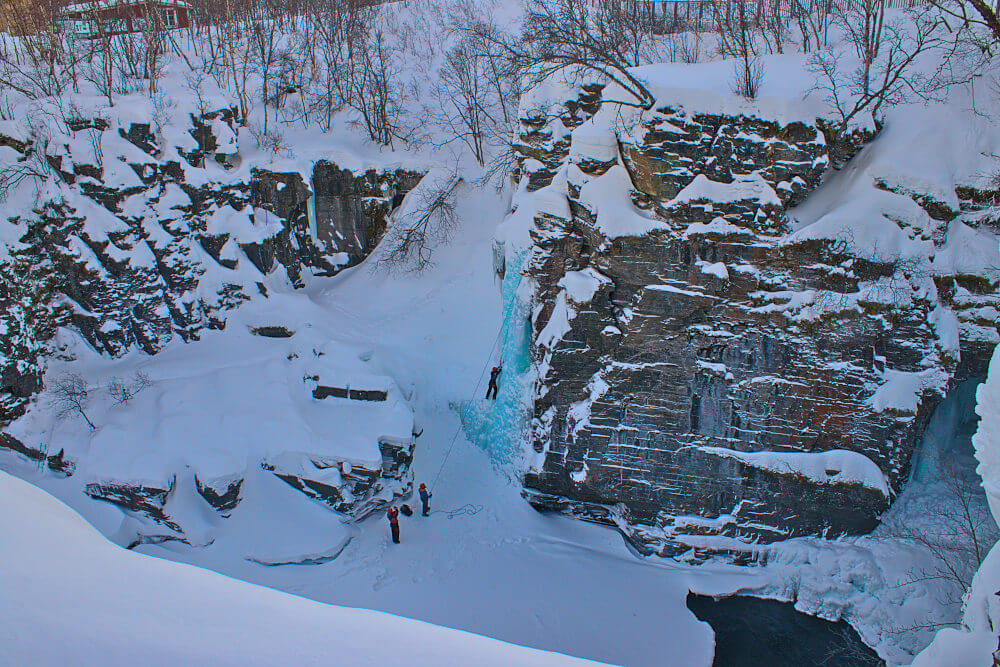 Ice-Climber am gefrorenen Wasserfall des Abiskojåkkas in Abisko im Winter